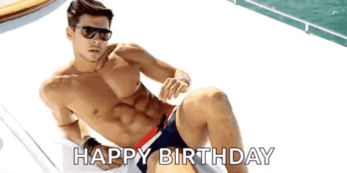 a shirtless man in a bathing suit is laying on a boat and says `` happy birthday '' .