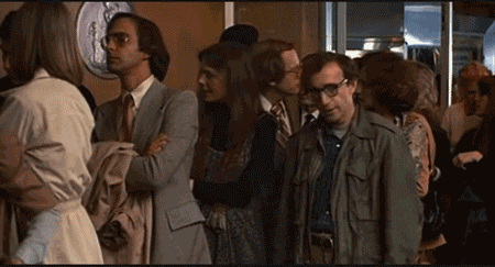 woody allen stands in front of a crowd of people in a line