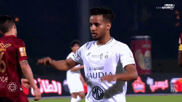 a soccer player wearing a white saudia jersey