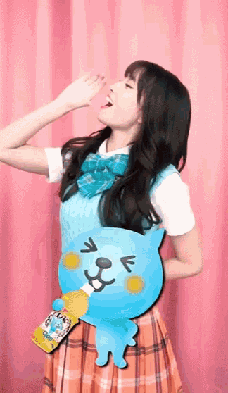 a girl in a plaid skirt is holding a bottle that says ok
