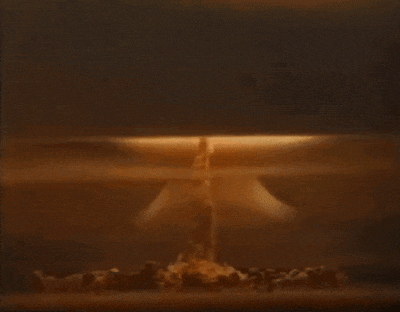 a close up of a nuclear explosion in a dark room with smoke coming out of it