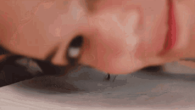 a close up of a woman 's face with a spider crawling out of her nose .