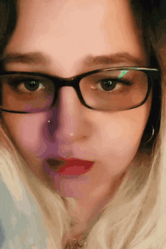 a close up of a woman 's face wearing glasses