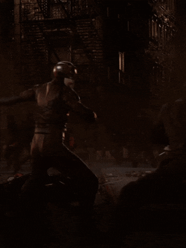 a man in a superhero costume is standing in a dark room