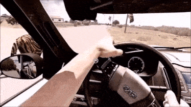 a person is driving a car with a steering wheel that says evo