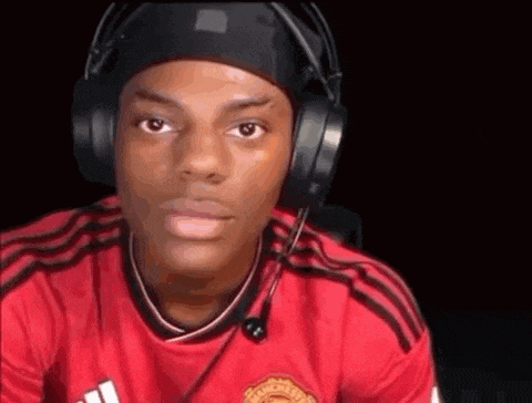 a man wearing headphones and a red shirt with a microphone on his head .