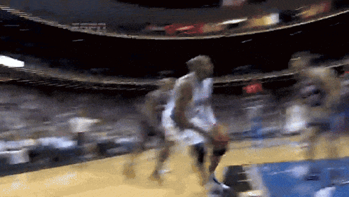a blurry picture of a basketball game with espn in the stands