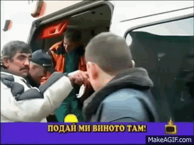 a group of men are standing in front of an ambulance with a banner that says makeagif.com