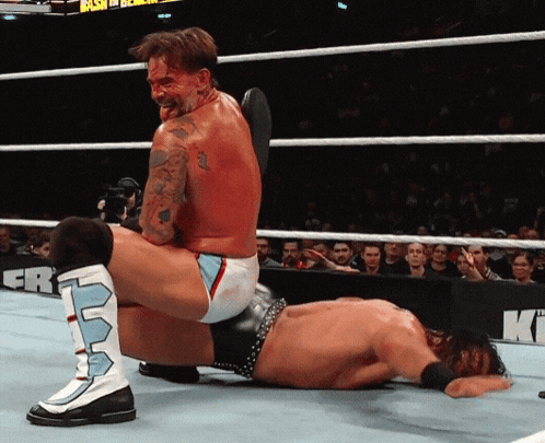 two wrestlers in a wrestling ring with a sign that says clash on it