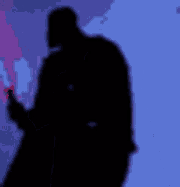 a silhouette of darth vader is holding a lightsaber in front of a blue background .