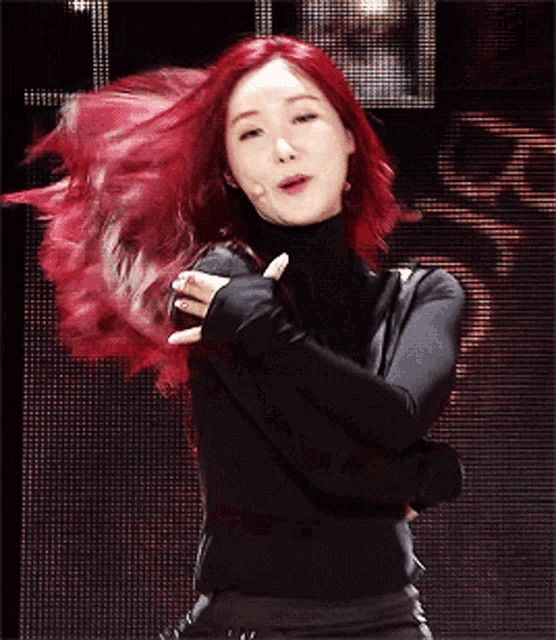 a woman with red hair is wearing a black turtleneck sweater