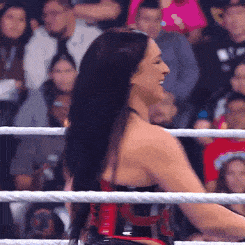 a woman in a wrestling ring with a rope around her waist that says ' tna ' on it