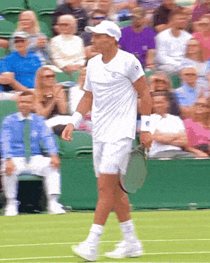 a man in a white shirt and white shorts is holding a tennis racquet