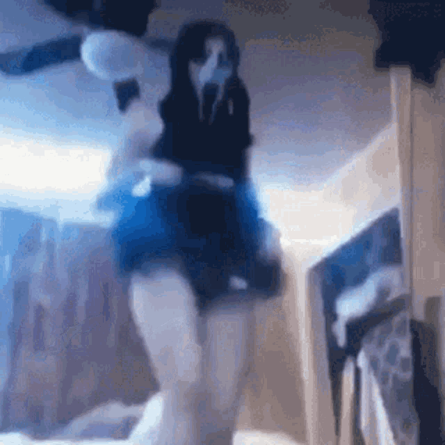 a woman in a blue skirt is dancing in a room with a ghost mask on her face .