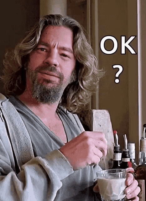 a man with long hair and a beard is holding a glass of milk and a question mark above his head that says ok