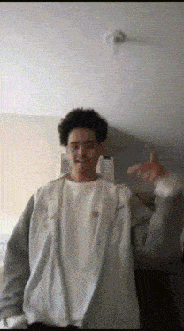 a man in a white shirt and gray jacket is dancing