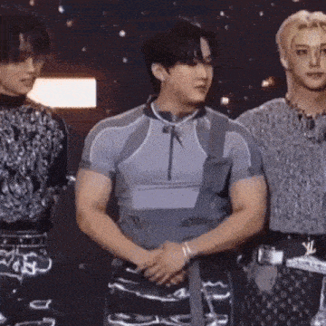 three men are standing next to each other on a stage .