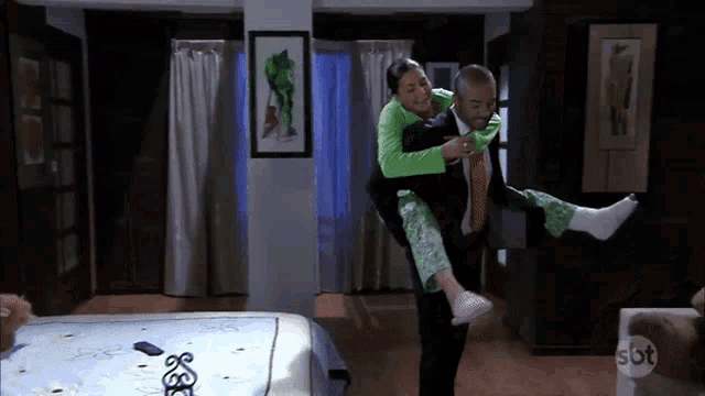 a man is carrying a woman on his shoulders with sbt written on the bottom