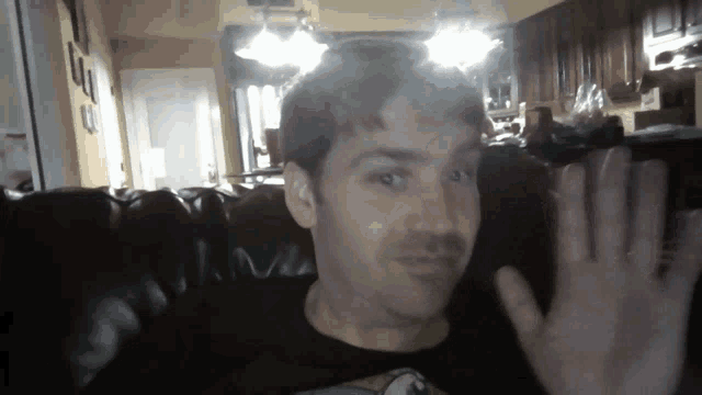 a man sitting on a couch with his hand in the air