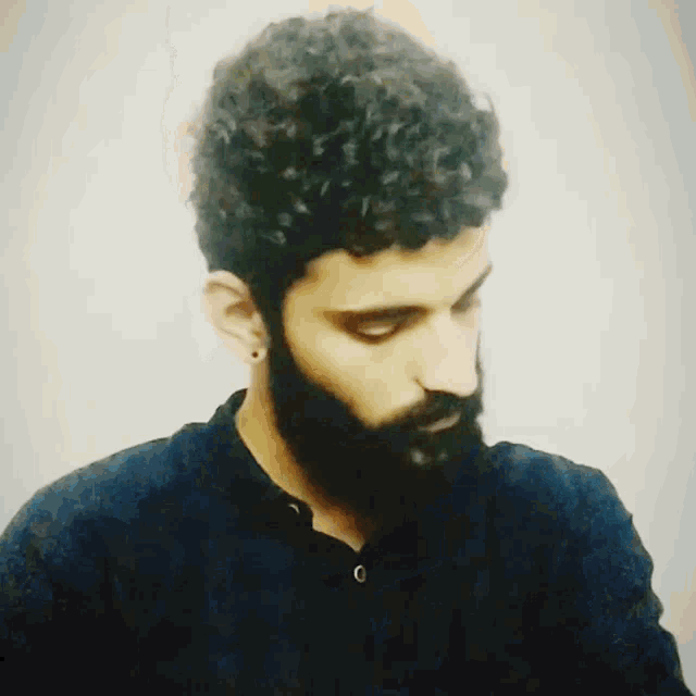 a man with a beard is wearing a black shirt