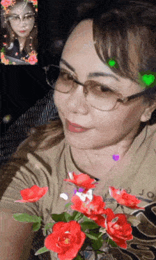 a woman wearing glasses is holding a bouquet of red roses