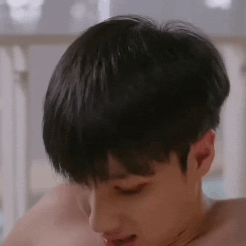 a young man without a shirt is taking a bath in a bathroom .