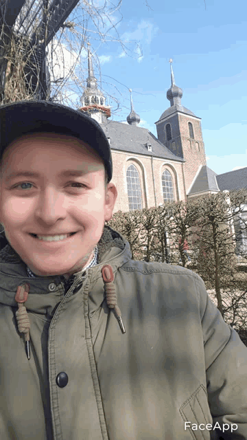 a man is smiling in front of a church with faceapp written on the bottom right