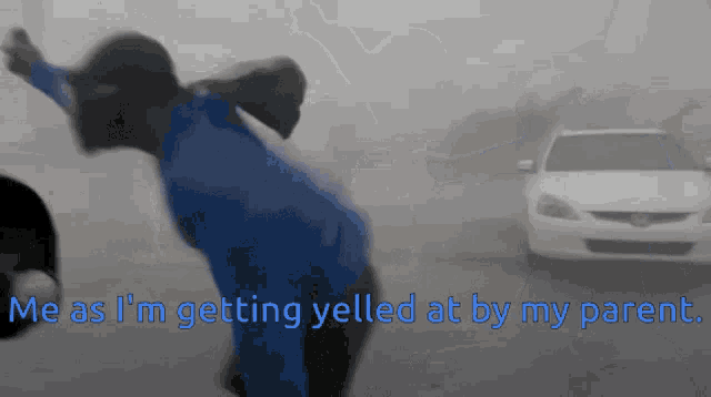 a person in a blue shirt is getting yelled at by a car
