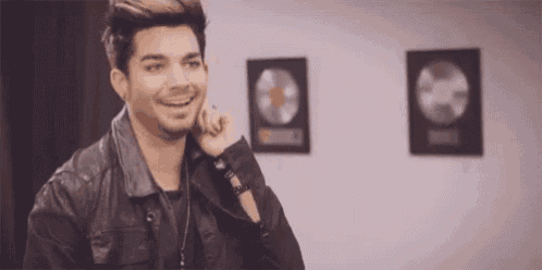 a man in a leather jacket is smiling and looking at the camera .