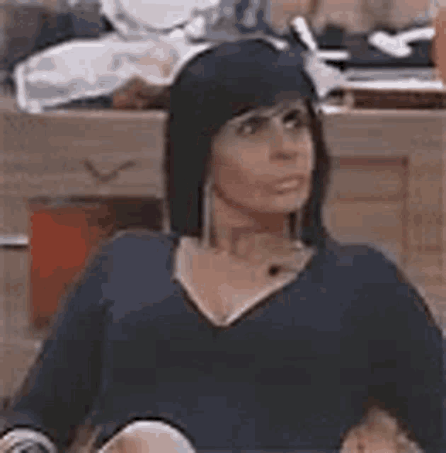 a woman in a black shirt is sitting in a chair .