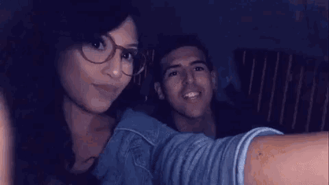 a man and a woman are taking a selfie in a dark room .