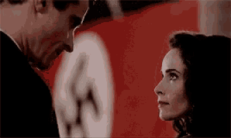 a man and a woman are looking at each other in front of a nazi flag .