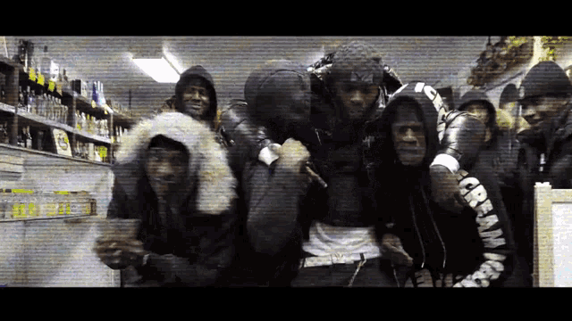 a group of men are posing for a picture and one of their hoodies says cream
