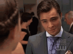 a man in a suit and tie is looking at a woman in a dress .