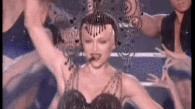a woman is singing into a microphone while dancing on a stage .