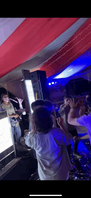 a man singing into a microphone while a crowd watches