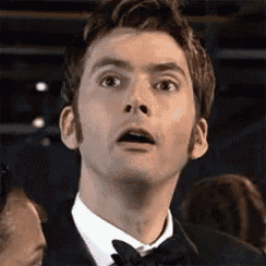 a man in a tuxedo and bow tie is making a funny face .