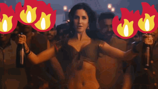 a woman is dancing in front of a crowd with flames behind her head