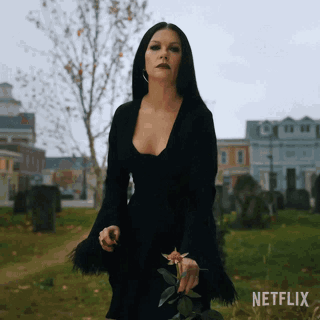 a woman in a black dress is holding a flower in a cemetery with netflix written on the bottom
