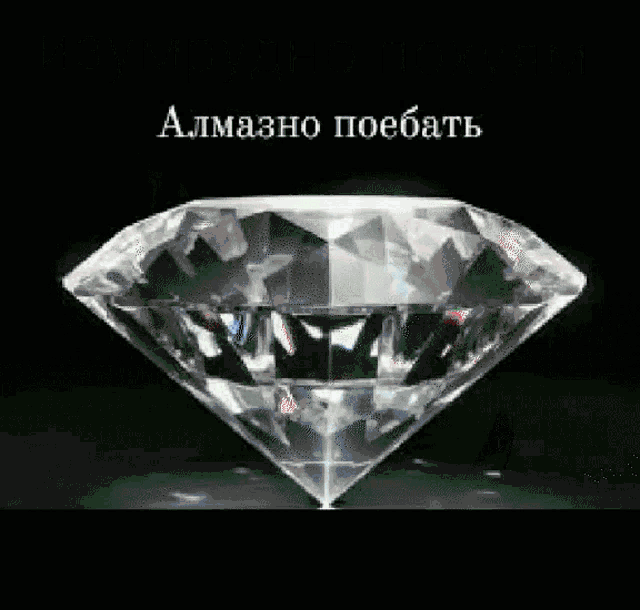 a large diamond is sitting on a black surface with a foreign language written above it .