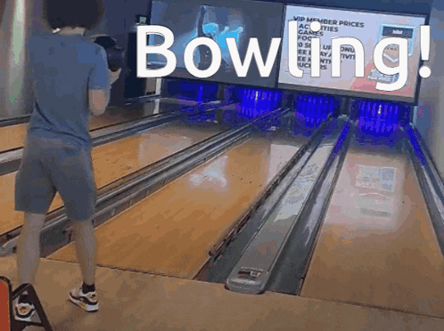 a man is playing bowling in front of a large screen that says bowling