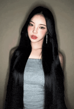 a woman with very long black hair is wearing a grey top