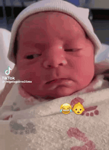 a baby is wearing a white hat and making a funny face while laying in a hospital bed .