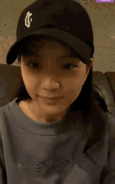 a woman wearing a baseball cap and a sweatshirt with the word adidas on the front