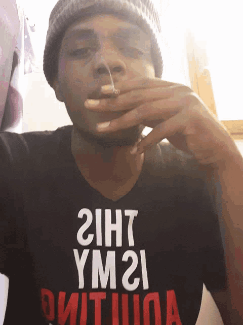 a man wearing a black shirt that says " 2iht ym21 " on it