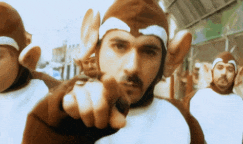 a man in a monkey costume pointing at the camera