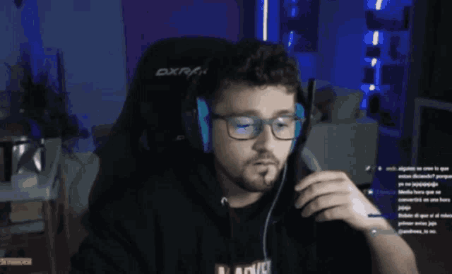 a man wearing glasses and headphones is sitting in a dxr gaming chair