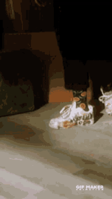 a person wearing a pair of sneakers with a gif maker watermark