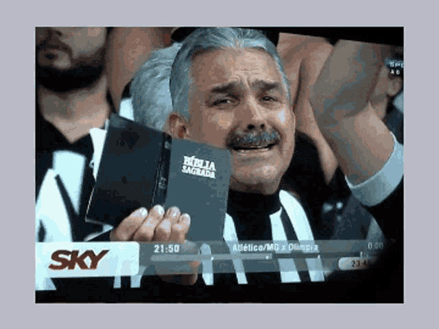 a man is holding a bible in front of a sky advertisement