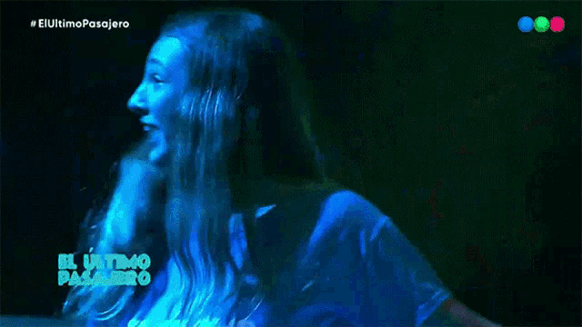 a woman in a blue shirt with the words el ultimo pasajero on the screen